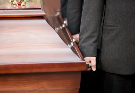 Pallbearers carry the casket to and from the hearse.